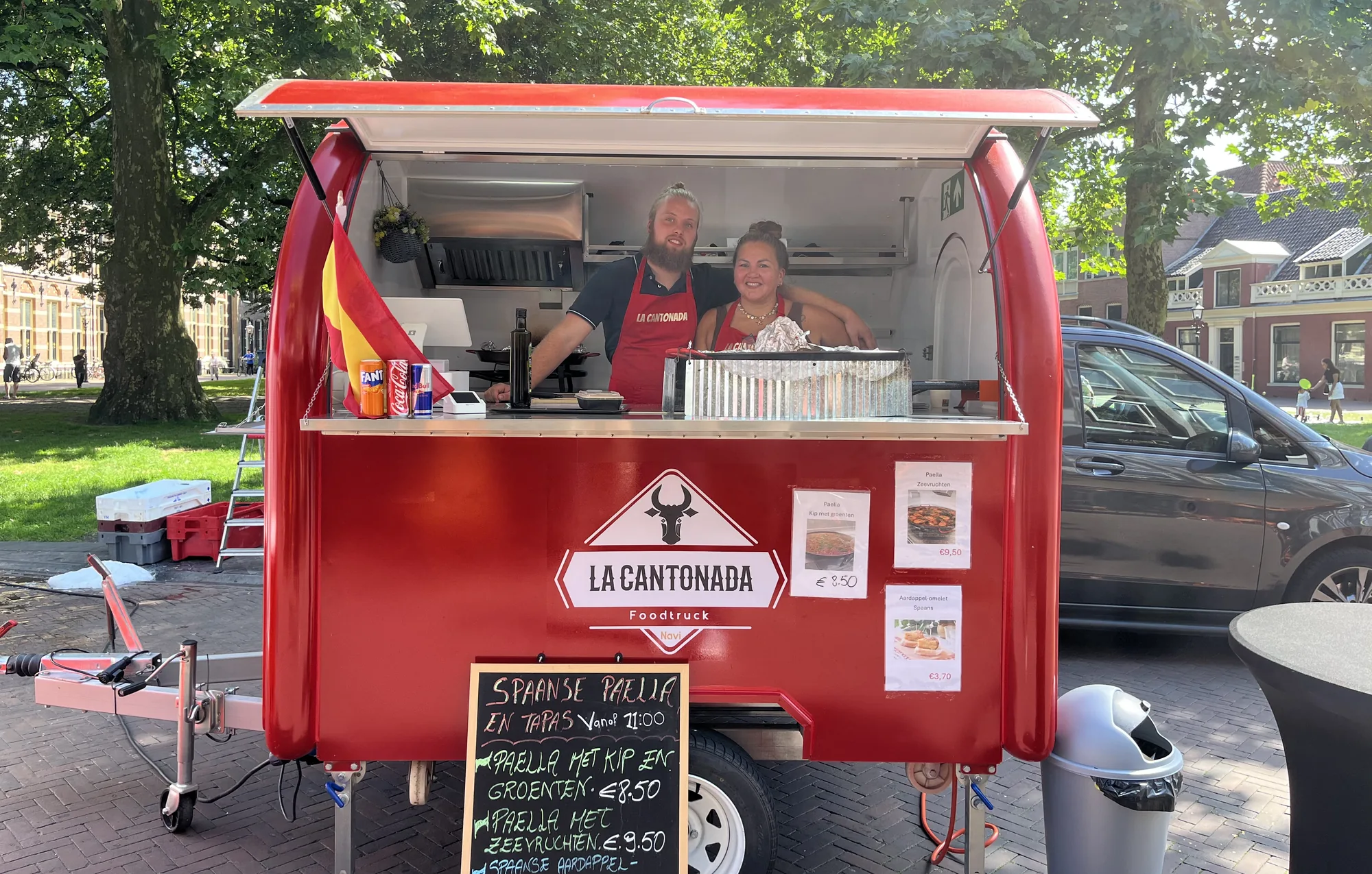 De kraam van La Cantonada met paellapannen op de markt in Assen